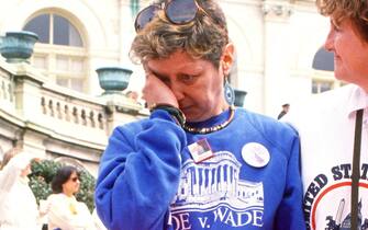 American activist Norma McCorvey (1947 - 2017) rubs her eye as she attends the March for Women's Lives outside the US Capitol, Washington DC, April 9, 1989. Known as Jane Roe, McCorvey was the plaintiff in the landmark 1973 United States Supreme Court decision Roe v Wade. (Photo by Ron Sachs/CNP/Getty Images)