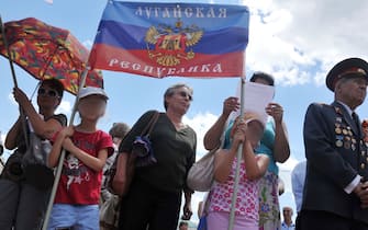 Children hold a flag of the so-called "People's Republic of Lugansk" during their rally in the eastern Ukrainian city of Lugansk on June 29, 2014, organized by pro-Russia separatists, activists, and armed militants and calling on the Ukraine government to stop its military operation in the east of the country. A spokesman for the Ukraine army's eastern military campaign stated five Ukrainian troops were killed and at least 17 wounded over the past 24 hours in the eastern regions of the country. German Chancellor Angela Merkel and French President Francois Hollande will join Ukraine's new leader on a call today to Russia's Vladimir Putin before Kiev's shaky truce with pro-Kremlin separatists expires. AFP PHOTO / ALEX INOY