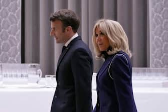 France's President Emmanuel Macron (L), flanked by his wife Brigitte (R) arrive to adress a speech at the Elysee Palace during a ceremony to honor 28 French medal-winning athletes at the Winter Olympics and Paralympics, in Paris, on March 29, 2022. (Photo by Francois Mori / POOL / AFP) (Photo by FRANCOIS MORI/POOL/AFP via Getty Images)