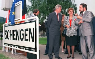 SCHENGEN, LUXEMBOURG - JUNE 19:  French minister for European affairs Edith Cresson (C) is flanked by Luxemburg's G. Wohlfahrt (D) and Belgium's Keersmaeker (L) in Schengen the day of the signature of the Schengen Agreement, 19 June 1990. Belgium, France, Luxemburg, the Netherlands and West Germany signed the agreement aimed at bringing about open borders by mid-1992.  (Photo credit should read CHARLES CARATINI/AFP via Getty Images)