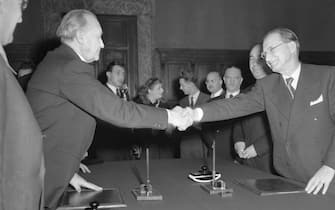 (Original Caption) Italo-German Cultural Pact Signed. Rome, Italy: Across a conference table, Italian premier Alcide de Gasperi (right) and West German chancellor Konrad Adenauer shake hands after signing the Italo-German Cultural Pact. Adenauer was in Rome for the six nation Schuman Plan conference.