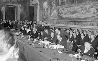 Beneath a fresco of The Horatii and Curatii by D'Arpino, statesmen of six European countries sign treaties for a European Common Market and European Atomic Pool. Seen here from left to right are Belgian Foreign Minister Paul Henri Spaak (extreme left), French Foreign Minister Christian Pineau (third from left), West German Chancellor and Foreign Minister Konrad Adenauer (center, signing) and his undersecretary Walter Hallstein (second from right), and Italian Prime Minister Antonio Segni.