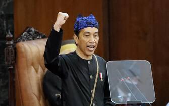 epa09416052 President Joko Widodo wearing traditional Baduy s outfit shouts  Merdeka  or  Freedom  during his annual speech in front of members of the parliament, ahead of the Independence Day at the parliament building in Jakarta, Indonesia, 16 August 2021. Indonesia will celebrate its Independence Day on 17 August, which will mark the day in 1945 when the Indonesian National Revolution began resisting against the Netherlands and pro-Dutch civilians.