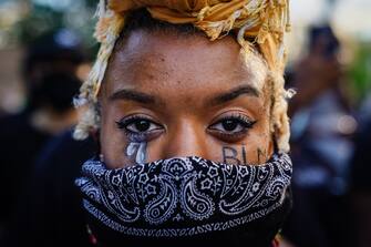 ATLANTA, GA - MAY 31: A woman with 'BLM' written on her cheek poses for a picture during a demonstration on May 31, 2020 in Atlanta, Georgia. Across the country, protests have erupted following the recent death of George Floyd while in police custody in Minneapolis, Minnesota. (Photo by Elijah Nouvelage/Getty Images)