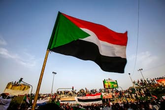 A Sudanese flag is seen waving as protesters chant slogans during a demonstration demanding a civilian body to lead the transition to democracy, outside the army headquarters in the Sudanese capital Khartoum on April 12, 2019. - Sudanese protestors vowed on April 12 to chase out the country's new military rulers, as the army offered talks on forming a civilian government after it ousted president Omar al-Bashir. (Photo by ASHRAF SHAZLY / AFP)        (Photo credit should read ASHRAF SHAZLY/AFP via Getty Images)