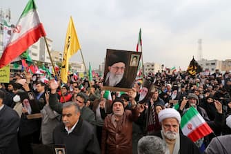 Iranians holding national flags and pictures of the Islamic republic's supreme leader, Ayatollah Ali Khamenei, take part a pro-government demonstration in the capital Tehran's central Enghelab Square on November 25, 2019, to condemn days of "rioting" that Iran blames on its foreign foes. - In a shock announcement 10 days ago, Iran had raised the price of petrol by up to 200 percent, triggering nationwide protests in a country whose economy has been battered by US sanctions. (Photo by ATTA KENARE / AFP) (Photo by ATTA KENARE/AFP via Getty Images)