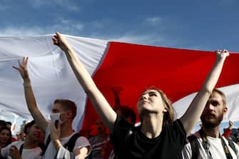 Opposition supporters carry a huge former white-red-white flag of Belarus during a rally to protest against the presidential election results in Minsk on September 13, 2020. - Belarus strongman Alexander Lukashenko, 66, who has been in power for 26 years, has vowed that he will not give up power to the opposition, which claims its candidate Svetlana Tikhanovskaya was the rightful winner of the August 9 polls. (Photo by - / TUT.BY / AFP) (Photo by -/TUT.BY/AFP via Getty Images)