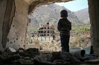 TOPSHOT - A photo taken on March 18, 2018, shows a Yemeni child looking out at buildings that were damaged in an air strike in the southern Yemeni city of Taez. / AFP PHOTO / Ahmad AL-BASHA        (Photo credit should read AHMAD AL-BASHA/AFP via Getty Images)