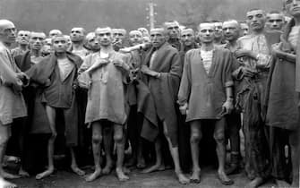 Starved jewish prisoners stand together at the Ebensee Concentration Camp after liberation by the US Army 80th Division May 7, 1945 in Ebensee, Austria.