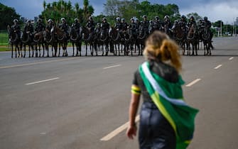 TOPSHOT - A demonstrator shouts at security forces while a camp set up by supporters of Brazil's far-right ex-president Jair Bolsonaro in front of the Army headquarters in Brasilia, is being dismantled by soldiers on January 9, 2023, a day after backers of the ex-president invaded the Congress, presidential palace and Supreme Court. - Brazilian security forces locked down the area around Congress, the presidential palace and the Supreme Court Monday, a day after supporters of ex-president Jair Bolsonaro stormed the seat of power in riots that triggered an international outcry. Hardline Bolsonaro supporters have been protesting outside army bases calling for a military intervention to stop Lula from taking power since his election win. (Photo by Mauro PIMENTEL / AFP) (Photo by MAURO PIMENTEL/AFP via Getty Images)