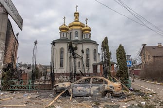 epa09807964 A Ukrainian military member stands guard next to a damaged church as people flee from the frontline town of Irpin, Kyiv (Kiev) region, Ukraine, 07 March 2022. Irpin, the town which is located near Kyiv city had heavy fightings for almost a week between Ukrainian and Russian militaries forcing thousands of people to escape from the town.  EPA/ROMAN PILIPEY