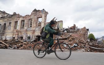 epa09907141 A local Ukrainian man ride bicycle in front of a destroyed shelling building in Kharkiv, Ukraine, 24 April 2022, amid Russian invasion.  EPA/VASILIY ZHLOBSKY
