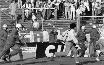 459824794 Belgium policemen run after Italian fans on May 29, 1985 in Heysel stadium in Brussels, as violence has broken out one hour before the European Champion Clubs final between Britain's Liverpool and Italy's Juventus of Turin, killing 39 fans and injuring more than 600. The tragedy occured when a wall collapsed in the stadium under the pressure of people and crushed Juventus fans as they tried to escape Liverpool supporters. (Photo credit should read DOMINIQUE FAGET/AFP via Getty Images)