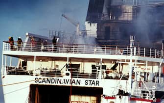 In this picture taken on April 8, 1990 clouds of smoke pour from the ferry Scandanavian Star as firefighters attempt to douse the blaze as it sits in dock in Lysekil a day after it was hit by a fire on the North Sea which killed 159 people.The Scandinavian Star car and passenger ferry caught fire between Oslo, Norway and Frederikshavn, Denmark in the evening of April 7, 1990, killing 159 people. AFP PHOTO/JOAKIM ROOS (Photo credit should read JOAKIM ROOS/AFP via Getty Images)