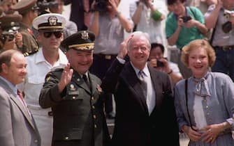 Former US President Jimmy Carter (C) waves to the press after he crosses the border into North Korea through the border truce village of Panmunjom for a four-day visit aimed at easing the peninsula's nuclear crisis 15 June 1994. On Carter's right is his wife Rosalynn.   Carter was awarded on 11 October 2002 the 2002 Nobel Prize for Peace.   AFP PHOTO  CHOO YOUN-KONG (Photo by CHOO YOUN-KONG / AFP) (Photo by CHOO YOUN-KONG/AFP via Getty Images)