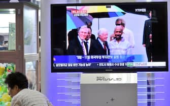 A woman walks past a TV screen reporting on former US president Jimmy Carter and Aijalon Mahli Gomes, an African-American who was jailed in North Korea, at a railway station in Seoul on August 27, 2010.  Former US president Jimmy Carter flew out of North Korea after securing the release of an American citizen and a pledge from Pyongyang that it wants to resume nuclear disarmament talks. AFP PHOTO/JUNG YEON-JE (Photo credit should read JUNG YEON-JE/AFP via Getty Images)