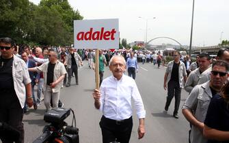 ANKARA, TURKEY - JUNE 15 : Kemal Kilicdaroglu (C), head of opposition Republican People's Party (CHP) holds a placard reading 'Justice' as he takes part in a protest march at Guvenpark after a CHP's deputy Enis Berberoglu was sentenced to 25 years in jail for revealing state secret in MIT trucks case in Ankara, Turkey on June 15, 2017.  (Photo by Evrim Aydin/Anadolu Agency/Getty Images)