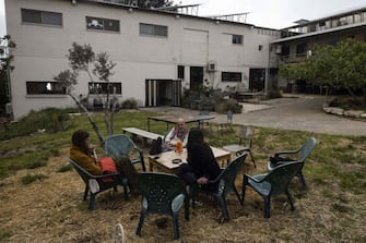Residents sit together in the Israeli kibbutz of Hanita on April 13, 2023. Entrepreneurs are repurposing the Israeli kibbutz into hubs for creative and hi-tech industries, after decades of decline in the rural communities once considered models of socialism. (Photo by MENAHEM KAHANA / AFP) (Photo by MENAHEM KAHANA/AFP via Getty Images)