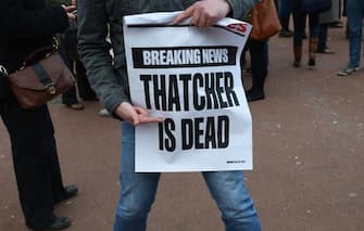 GLASGOW, UNITED KINGDOM - APRIL 08:  A man poses with a sign displaying the message 'Thatcher is Dead' as other members of the public gather in George Square to mark the death of Baroness Margaret Thatcher on April 8, 2013 in Glasgow, Scotland. It has been confirmed that Lady Thatcher has died this morning following a stroke aged 87. Margaret Thatcher was the first female British Prime Minster and governed the UK from 1979  to 1990. She led the UK through some turbulent years and contentious issues including the Falklands War, the miners' strike and the Poll Tax riots.  (Photo by Jeff J Mitchell/Getty Images)