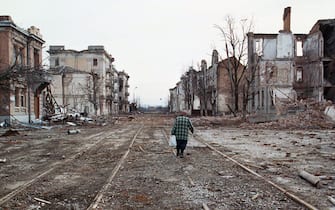 MOS03-20000319-GROZNY, CHECHNYA, RUSSIAN FEDERATION: With scenes of devasation flanking both sides of the tramway tracks, a localwoman resident walks through the deserted scene in the Chechen capital of Grozny Sunday 19th March 2000.   Chechen rebels vowed on Sunday to give acting president Vladimir Putin a bloody nose ahead of Russian presidential elections, as they slipped away from federal troops to regroup in the mountainous southeast of Chechnya. EPA PHOTO/STR