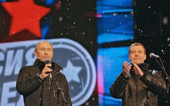 Russian President Vladimir Putin (L) looks on as his likely successor Dmitry Medvedev applauds during a surprise appearance at a rock concert near Red Square in Moscow on March 2, 2008 after the release of preliminary results. Putin congratulated his handpicked successor Dmitry Medvedev on his projected victory in Sunday's presidential vote, at a Red Square rock concert. "I congratulate (Medvedev) and wish him success" Putin said, standing by Medvedev on a specially-erected stage. AFP PHOTO/RIA NOVOSTI/KREMLIN POOL/DMITRY ASTAKHOV (Photo credit should read DMITRY ASTAKHOV/AFP via Getty Images)