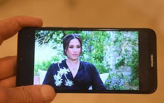 epa09062891 A person watches on a mobile phone the ITV broadcast in the UK of the interview by US talk show host Oprah Winfrey with Britain's Prince Harry and Meghan Markle, the Duke and Duchess of Sussex, in London, Britain, 08 March 2021. ITV aired the interview in the United Kingdom at 9pm.  EPA/FACUNDO ARRIZABALAGA