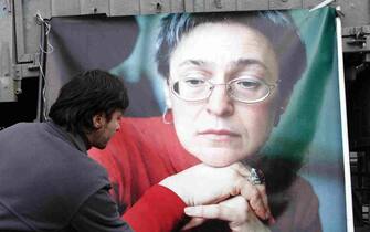  Russian man lays flowers near the picture of murdered journalist Anna Politkovskaya, during a rally in Moscow, Russia, 07 October 2009.ANSA/MAXIM SHIPENKOV