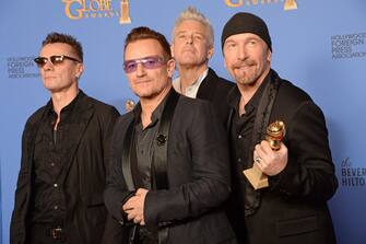 (FROM LEFT): Musicians Larry Mullen Jr., Bono, Adam Clayton and The Edge of U2 pose in the press room after winning the Golden Globe for Best Original Song for "Ordinary Love" from "Mandela: Long Walk to Freedom," in the press room at the 71st annual Golden Globe Awards in Beverly Hills, California, January 12, 2014.  AFP PHOTO / ROBYN BECK        (Photo credit should read ROBYN BECK/AFP via Getty Images)