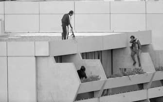 (Original Caption) 9/5/72 - Munich: Armed police drop into position on a terrace directly above the apartments where between nine and 26 members of the Israeli Olympic team are being held hostage 9/5 by Arab "Black September" extremeists. The extremists raided the Israeli quarters in the early morning hours and shot and killed a wrestling coach as they forced their way in.