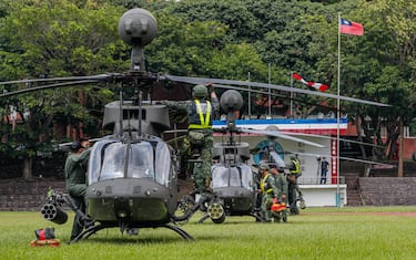 epa10091817 Taiwanese air force personnel conduct a post-flight inspection after Taiwan s OH-58D attack helicopters landed inside a school's track and field area, during a landing drill as part of the Han Kuang military exercise in Hsinchu, Taiwan, 26 July 2022. The drill is part of the Taiwan's annual Han Kuang military exercise that simulates response to enemies attack on major targets in Taiwan.  EPA/RITCHIE B. TONGO
