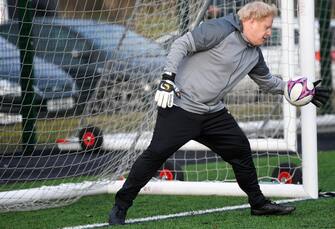 CHEADLE HULME, UNITED KINGDOM - DECEMBER 07: British Prime Minister Boris Johnson takes a turn in goal during the warm up before a girls' soccer match between Hazel Grove United JFC and Poynton Juniors on December 7, 2019 in Cheadle Hulme, United Kingdom. The Prime Minister is campaigning in the North West ahead general election on December 12. (Photo by Toby Melville - WPA Pool/Getty Images)