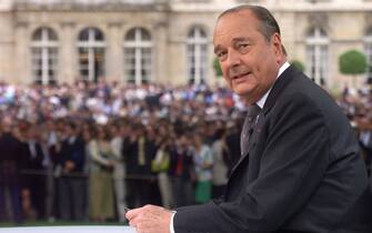 French President Jacques Chirac poses for photographer, 14 July 1999 prior a televised interview as guests to the traditional garden-party stand in front of the Elysee Palace, following the annual military parade in Paris. In a live Bastille Day television interview Chirac brushed aside suggestions from within his troubled conservative camp that he cut short his seven-year mandate and hold new elections next year. (Photo by Georges GOBET / AFP)        (Photo credit should read GEORGES GOBET/AFP via Getty Images)