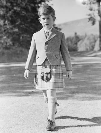 (Original Caption) All This and Seven, Too. Balmoral, Scotland: Resplendent in a kilt of Balmoral tartan, restricted to members of the royal family, Prince Charles, son of Queen Elizabeth II and the Duke of Edinburgh, poses for this 7th birthday portrait in the grounds of Balmoral Castle. The young prince looks very much like his father. For now on he will begin his training for kingship. Charles' full title is Prince Charles Arthur George, duke of Cornwall and Rothesay, earl of Carrick, baron Renfrew, lord of the isles and great steward of Scotland.