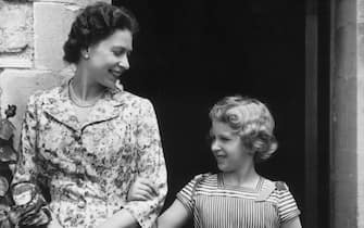 circa 1960:  Queen Elizabeth II with her only daughter and second child, Princess Anne arm-in-arm in the gardens of Windsor Castle.  (Photo by Lisa Sheridan/Studio Lisa/Hulton Archive/Getty Images)