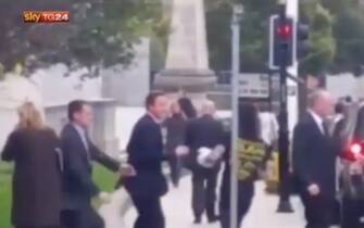 Un fermo immagine del video in cui si vede un ragazzo avvicinarsi di corsa a David Cameron