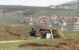 Serbian policemen take their position near the village of Donje Prekaze, in the Serbian province of Kosovo, 08 March 1998. The village of Prekaz was attacked on March 1998 by the Serbian security forces, killing 51 people. This village is situated in the central Kosovo region of Drenica, seen by the government in Belgrade as the stronghold of the Albanian separatists. / AFP PHOTO / EPA  FILES / SRDJAN SUKI        (Photo credit should read SRDJAN SUKI/AFP via Getty Images)