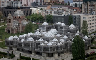 PRISTINA, KOSOVO - MAY 02: The unfinished Serbian Orthodox church of Christ the Savior is seen behind the national library of Kosovo on May 2, 2019 in Pristina, Kosovo. A recent EU-backed summit failed to restart negotiations between leaders from Kosovo and Serbia over a final resolution of Kosovo’s sovereignty. In previous talks, the countries’ presidents have signaled an openness to land swaps, which could see the majority-Serb areas north of the Ibar River annexed into Serbia. In the northern city of Mitrovica, the Ibar River divides the city, with Serbs dominating the north and ethnic Albanians to the south. In exchange for ceding areas above the Ibar, Kosovo would take the predominantly ethnic Albanian area of the Presevo Valley in southern Serbia. Many political leaders in Kosovo and across Europe are vehemently opposed to ethnic partition and land swaps, fearing that a change in borders could reignite a conflict that resulted in thousands of deaths from 1998 to 1999. During the conflict, Serbian forces started an ethnic cleansing campaign which pushed approximately one million predominantly muslim Kosovar Albanians from their homes. After diplomatic solutions failed, NATO intervened with a 78-day, United-States led bombing campaign to force Serbian troops to withdraw. After nine years under United Nations control, Kosovo declared independence from Serbia in 2008. Since the declaration, Kosovo has been recognized by 111 of the United Nation’s 193 member states. Serbia, Russia, China and five EU countries still do not recognize it, keeping the country into a state of limbo. (Photo by Chris McGrath/Getty Images)