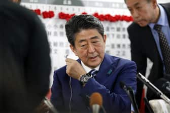 epa06282469 Japanese Prime Minister Shinzo Abe (C) wears off earphone as he attends at headquarters of the ruling Liberal Democratic Party (LDP) in Tokyo, Japan, 22 October 2017 after close of vote of the Lower House election.  The LDP and a coalition partner are expected to win landslide victory in the election.  EPA / KIMIMASA MAYAMA