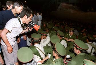 BEIJING, CHINA - JUNE 3:  Using a loudspeaker, a student asks soldiers to go back to their barracks as crowds flooded into the central Beijing 03 June 1989.  On the night of 03 and 04 June 1989, Tiananmen Square sheltered the last pro-democracy supporters as Chinese troops marched on the square to end a weeks-long occupation by student protestors, using lethal force to remove opposition it encountered along the way. Hundreds of demonstrators were killed in the crackdown as tanks rolled into the environs of the square.   AFP PHOTO  (Photo credit should read CATHERINE HENRIETTE/AFP via Getty Images)