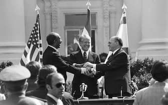 Egyptian President Anwar Sadat, President Jimmy Carter and Israeli Prime Minister Menachem Begin share a three way handshake after the signing of the Camp David Accords Peace Treaty between Egypt and Israeli on the north lawn of the White House.