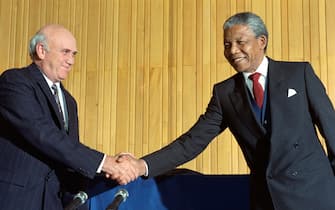 TOPSHOT - South Africa's President F.W. de Klerk (L) and anti-apartheid leader and African National Congress (ANC) member Nelson Mandela shake hands on May 04, 1990 at a joint press briefing, after historic "talks about talks" between the South African government and the ANC in Cape Town. (Photo by RASHID LOMBARD / AFP) (Photo by RASHID LOMBARD/AFP via Getty Images)
