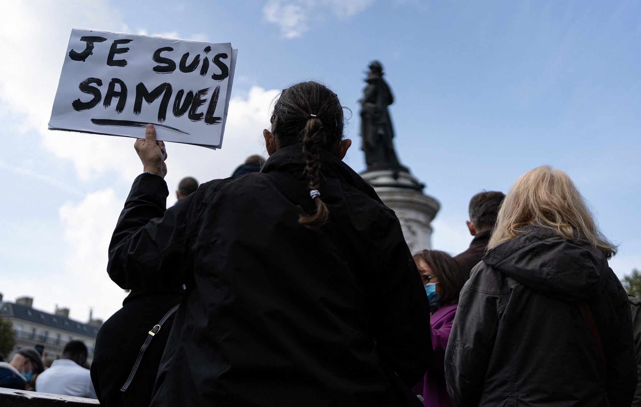 745340_025 A woman holds a sign saying "I am Samuel". People are demonstrating in Republic Square at the call of Charlie Hebdo and SOS Racism to pay tribute to Professor Samuel Paty, assassinated Friday for showing his students caricatures of Mohammed. Paris, France, October 18, 2020. Photo by Florent Bardos/ABACAPRESS.COM