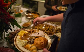 Unidentified diners serve themselves food at a traditional Thanksgiving Day family gathering in Bloomfield Hills, Michigan on November 26, 2015. (Photo by Robert Nickelsberg/Getty Images)