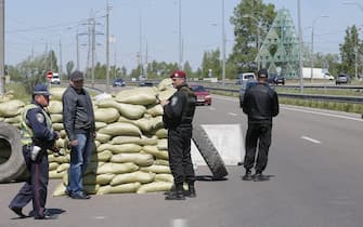 epa04196519 Ukrainian policemen and self-defense activists stand guard near of a checkpoint in Kiev, Ukraine, 08 May 2014. Pro-Russian forces in Ukraine have been pressing for the 11 May referendum in the provinces of Lugansk and Donetsk, arguing that they want to be independent from Ukraine and merged with a greater Russia. A referendum on independence for eastern Ukrainian independence needs to be delayed and peace restored in the region, said Russian President Vladimir Putin 07 May, even as government and separatist forces clashed anew.  EPA/SERGEY DOLZHENKO