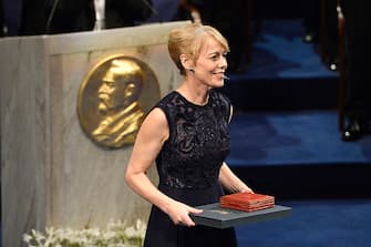 STOCKHOLM, SWEDEN - DECEMBER 10:  Alice Munro, laureate of the Nobel Prize in Literature, represented by her daughter Jenny Munro acknowledges applause after she received her Nobel Prize from King Carl XVI Gustaf of Sweden during the Nobel Prize Awards Ceremony at Concert Hall on December 10, 2013 in Stockholm, Sweden.  (Photo by Pascal Le Segretain/Getty Images)