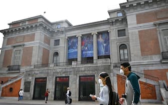 Tourists wearing protective face masks walk in front of El Prado museum in Madrid on March 12, 2020, after all of Madrid's state-run museums were closed to the public due to the coronavirus outbreak. - Spain struggles to handle a quadrupling of cases in three days, taking the number of infections above 2,000 and 48 dead, with Madrid the worst-hit area accounting for more than half of the cases. (Photo by GABRIEL BOUYS / AFP) (Photo by GABRIEL BOUYS/AFP via Getty Images)