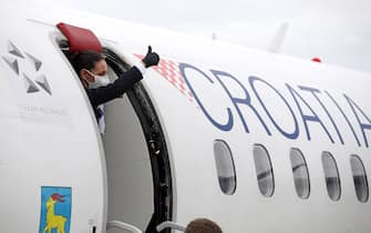 Stewardess gestures from a plane coming from Split upon landing at Zagreb International Airport Croatia, on May 11, 2020 as air traffic resumed after two months, while Croatia prepares to ease lockdown measures in place to curb the spread of the COVID-19 pandemic, caused by the novel coronavirus. (Photo by Damir SENCAR / AFP) (Photo by DAMIR SENCAR/AFP via Getty Images)