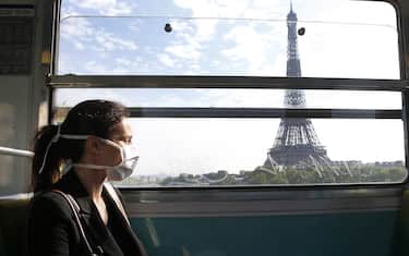 PARIS, FRANCE - APRIL 24: A passenger wearing a protective face mask is seen in a subway train as she passes in front the Eiffel Tower as the lockdown continues due to the coronavirus outbreak (COVID 19) on April 24, 2020 in Paris, France. After a meeting between the Head of State Emmanuel Macron and the mayors, the Elysee Palace said that the wearing of the mask will probably be compulsory in public transport, starting on May 11. The Coronavirus (COVID-19) pandemic has spread to many countries across the world, claiming over 191,000 lives and infecting over 2.7 million people. (Photo by Chesnot/Getty Images)