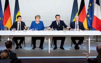 Emmanuel Macron, France's president, second right, speaks to a journalist as he sits alongside Volodymyr Zelenskiy, Ukraine's president, left, Angela Merkel, Germany's chancellor, second left, and Vladimir Putin, Russia's president, during a news conference following a 4-way summit on Ukraine at Elysee Palace in Paris, France, on Monday, Dec. 9, 2019. Putin and Zelenskiy breathed new life into efforts to end the violence in eastern Ukraine, agreeing at a summit in Paris on Monday to a fresh exchange of prisoners and the withdrawal of some troops. Photographer: Christophe Morin/Bloomberg