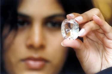 BANGALORE, INDIA:  Executive Director of Jewels de Paragon (JDP) Pavana Kishore shows the "Koh-I-Noor" diamond on display with other famous diamonds at an exhibition intitled "100 World Famous Diamonds" in Bangalore 19 May 2002. The Koh-I-Noor diamond, which once belonged to Mughal Emperor Shah Jehan, weighs 105.60 Carats and is part of the British crown jewels, stored in the tower of London. AFP PHOTO (Photo credit should read STR/AFP via Getty Images)